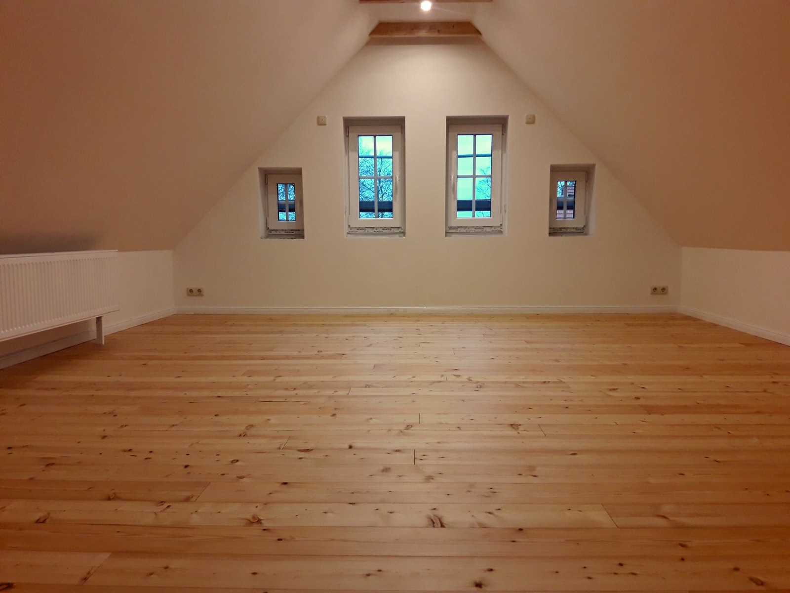 Neu verlegter heller Holzboden in einem Dachgeschoss