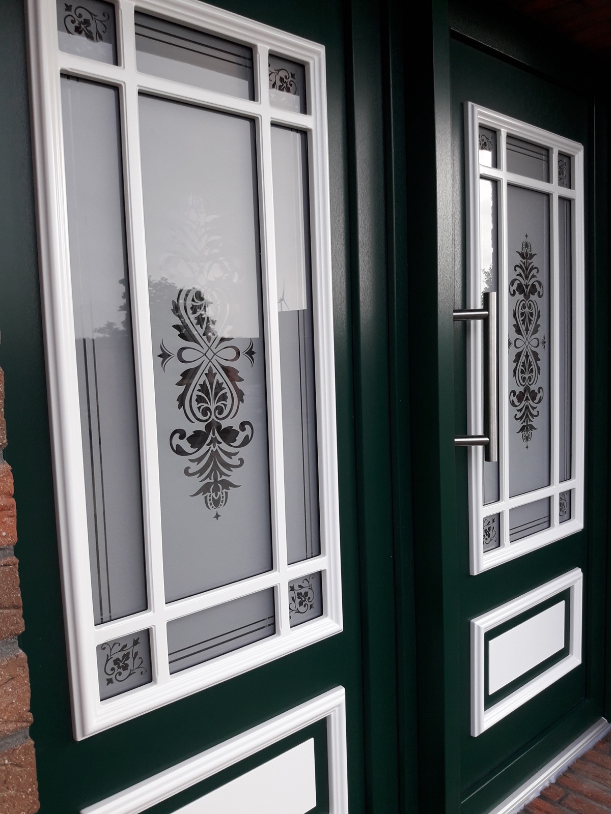 Dunkelgrüne Haustür mit weißen Glaselementen